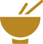 A simple illustration of a bowl with chopsticks. The image is in a single color, a mustard yellow, with the bowl positioned slightly off-center and the chopsticks tilted diagonally so that one chopstick is partially inside the bowl.
