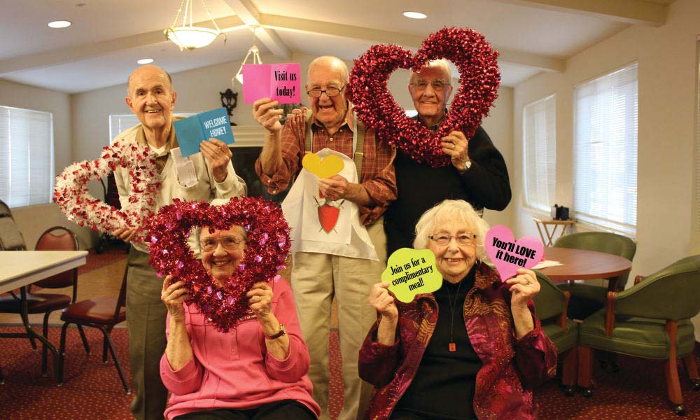 Senior residents smiling with hearts for Valentines day photo