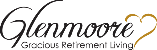 A logo with the word "Glenmoore" in elegant script and "Gracious Retirement Living" in capital letters underneath. A gold heart outline accentuates the design.