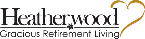 Logo of Heatherwood Gracious Retirement Living. The name "Heatherwood" is written in large black font with the phrase "Gracious Retirement Living" below in smaller font. To the right, there is a stylized golden heart.