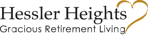 Logo for Hessler Heights Gracious Retirement Living. The text "Hessler Heights" is prominent, followed by "Gracious Retirement Living" in smaller text. A stylized yellow heart is integrated into the design, wrapping around the word "Heights.