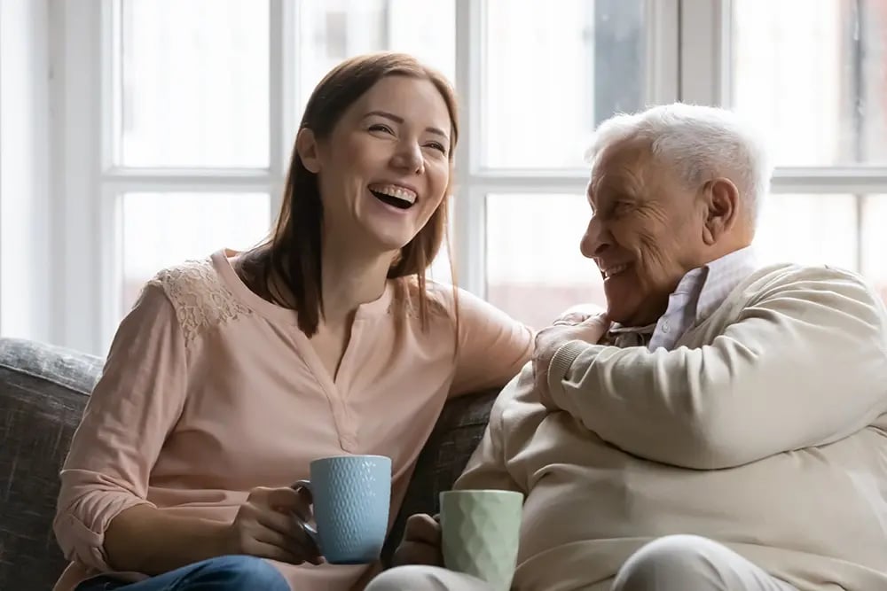 Man and woman sitting on couch having coffee