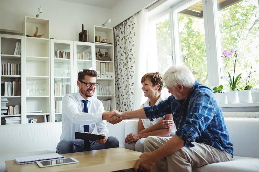 Staff talking to senior man and woman