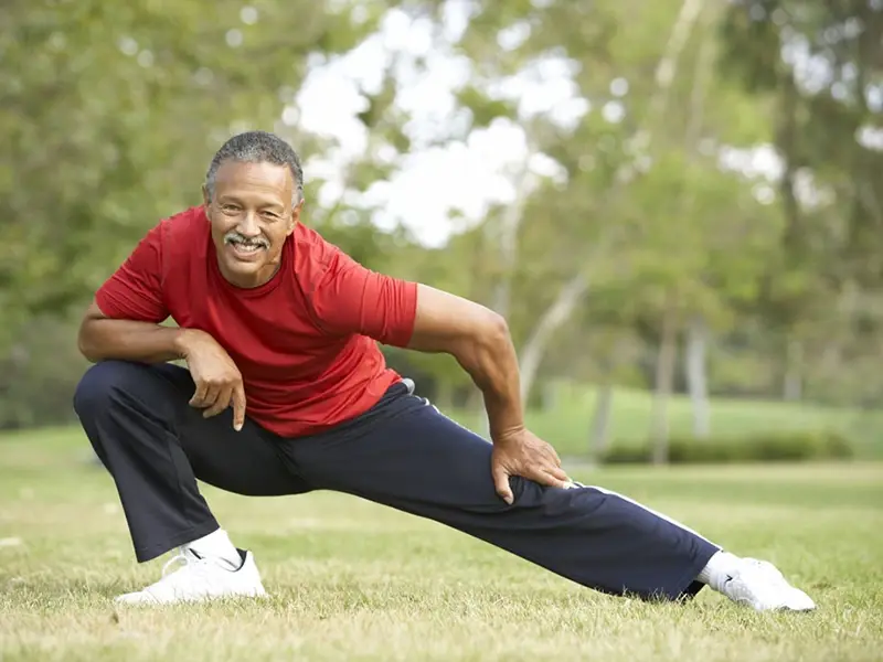 senior-man-stretching-lawn