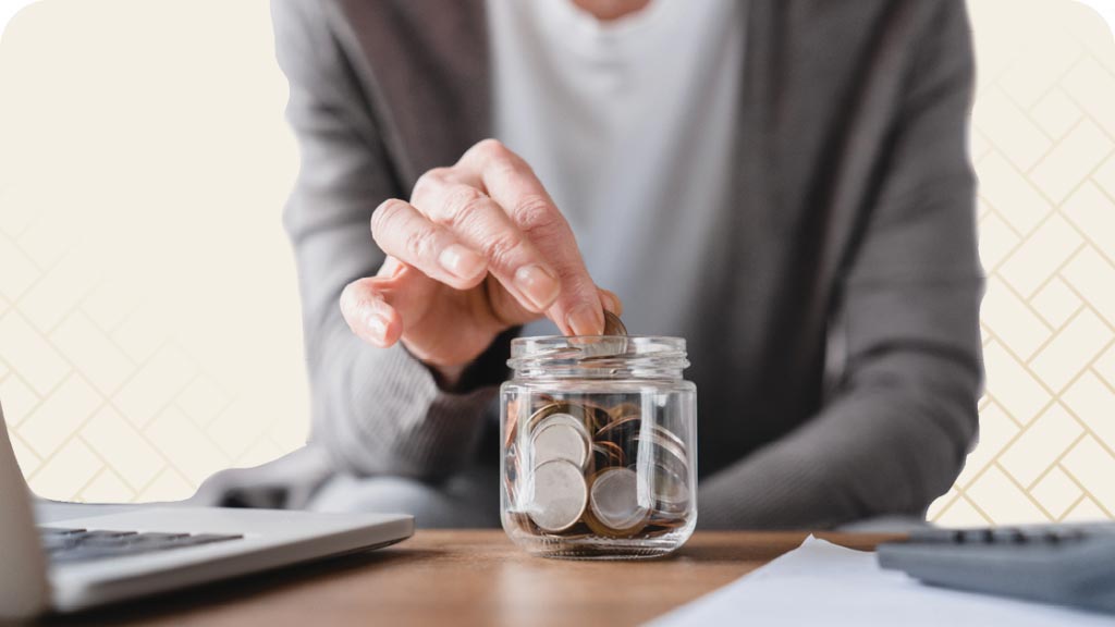 Close up of woman putting money in a jar