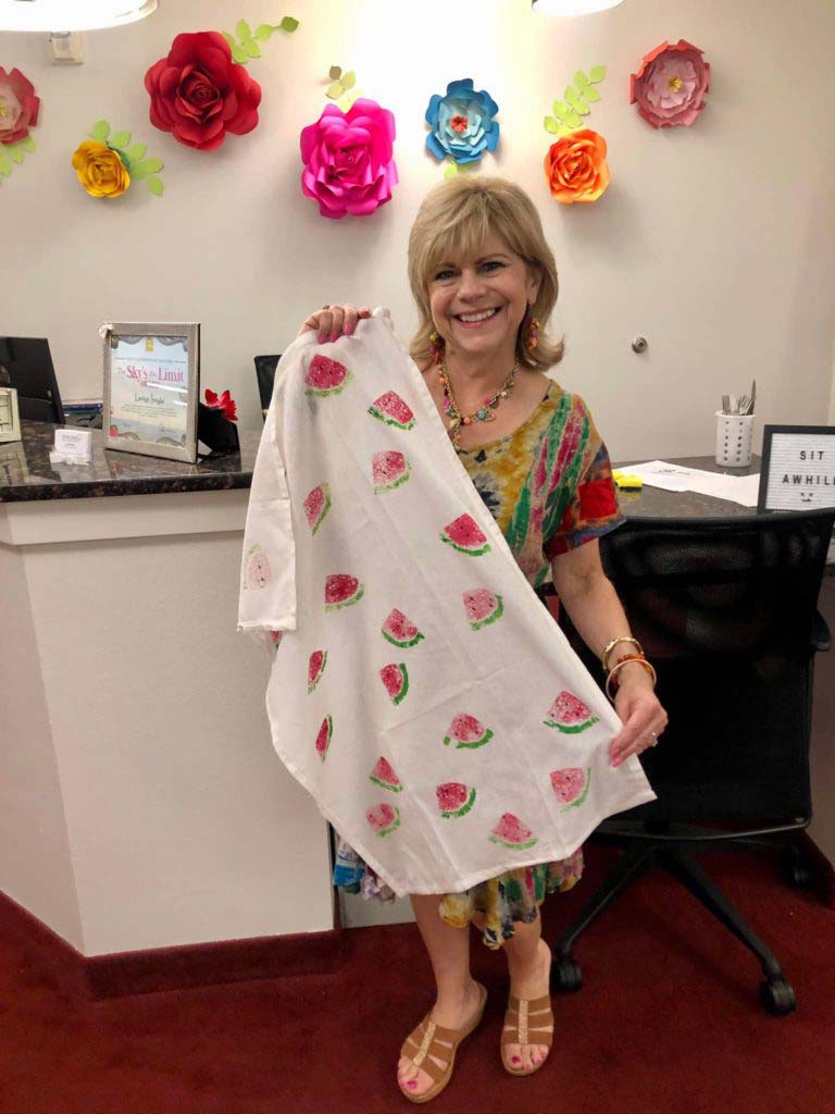Young woman holding up some fabric with watermelons