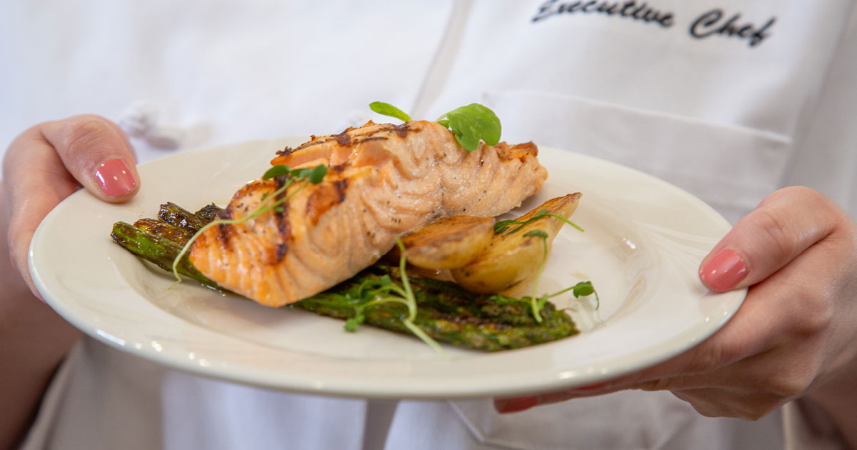 A person wearing a white chef's coat with 