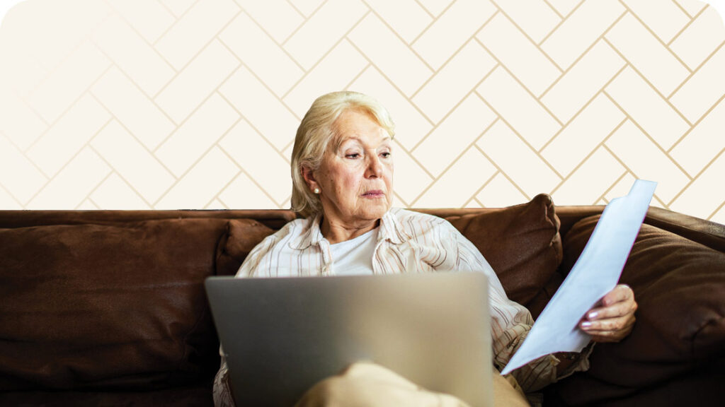 Senior woman reviewing paperwork on couch