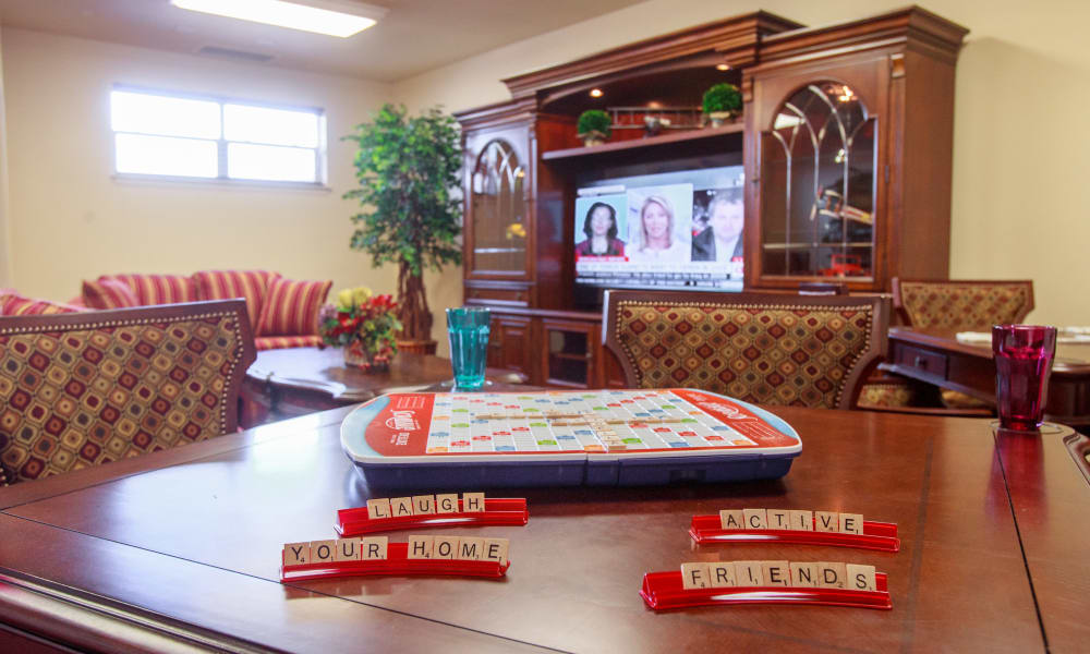 A cozy living room with a Scrabble game set up on a wooden table. The Scrabble tiles spell out 