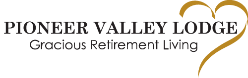 Logo of Pioneer Valley Lodge. It consists of the text "Pioneer Valley Lodge Gracious Retirement Living" next to a stylized golden heart shape.