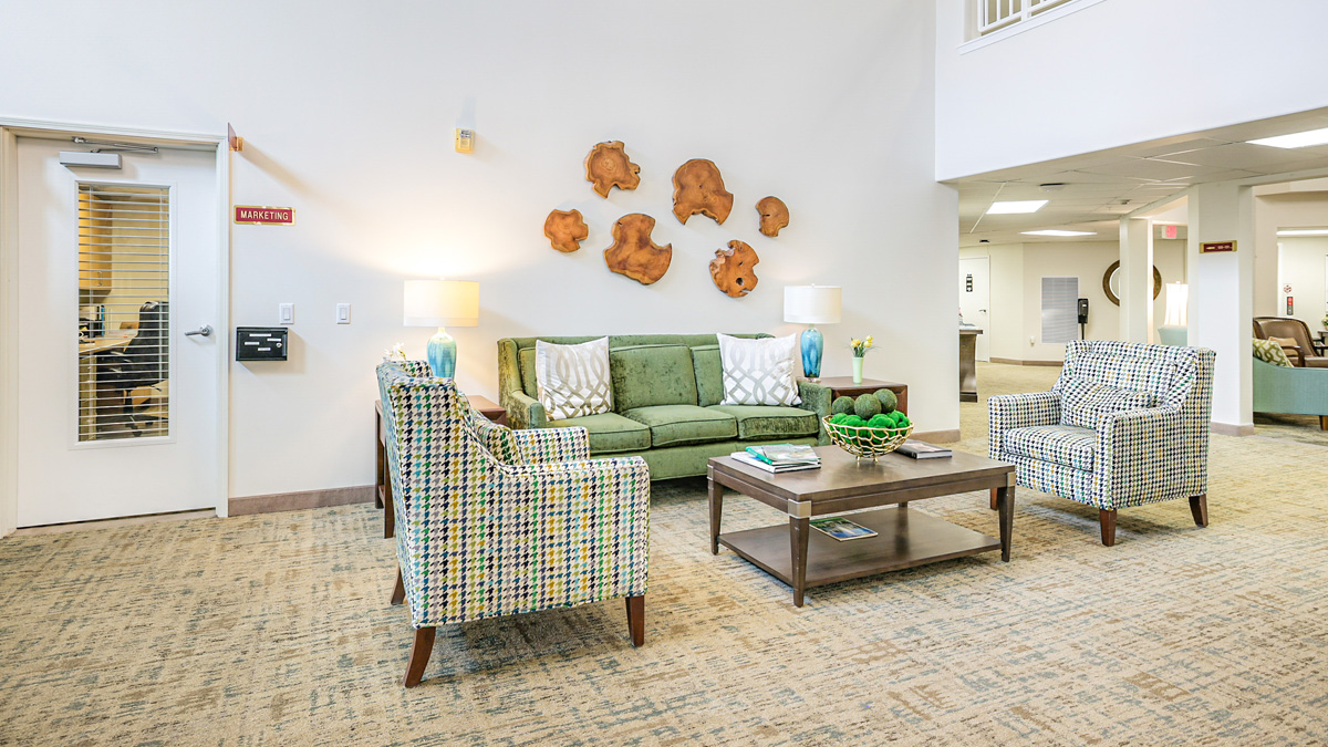 A room with a green couch and a coffee table.