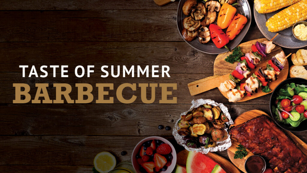 Overhead view of grilled vegetables, corn, skewers, salad, ribs, and potatoes on wooden table, with text "Taste of Summer Barbecue" on the left.