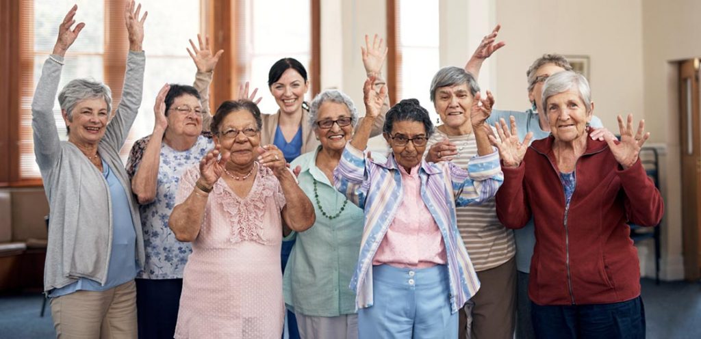 Several seniors posing for a picture with their hands up and smiling