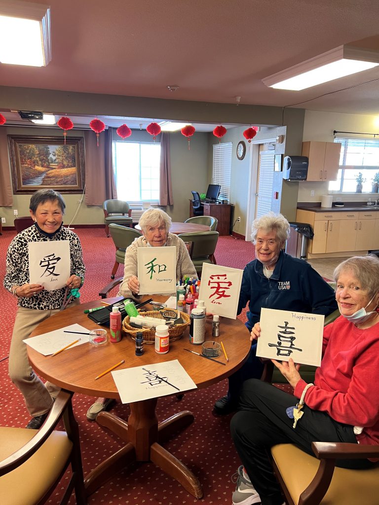 Senior residents painting Chinese symbols