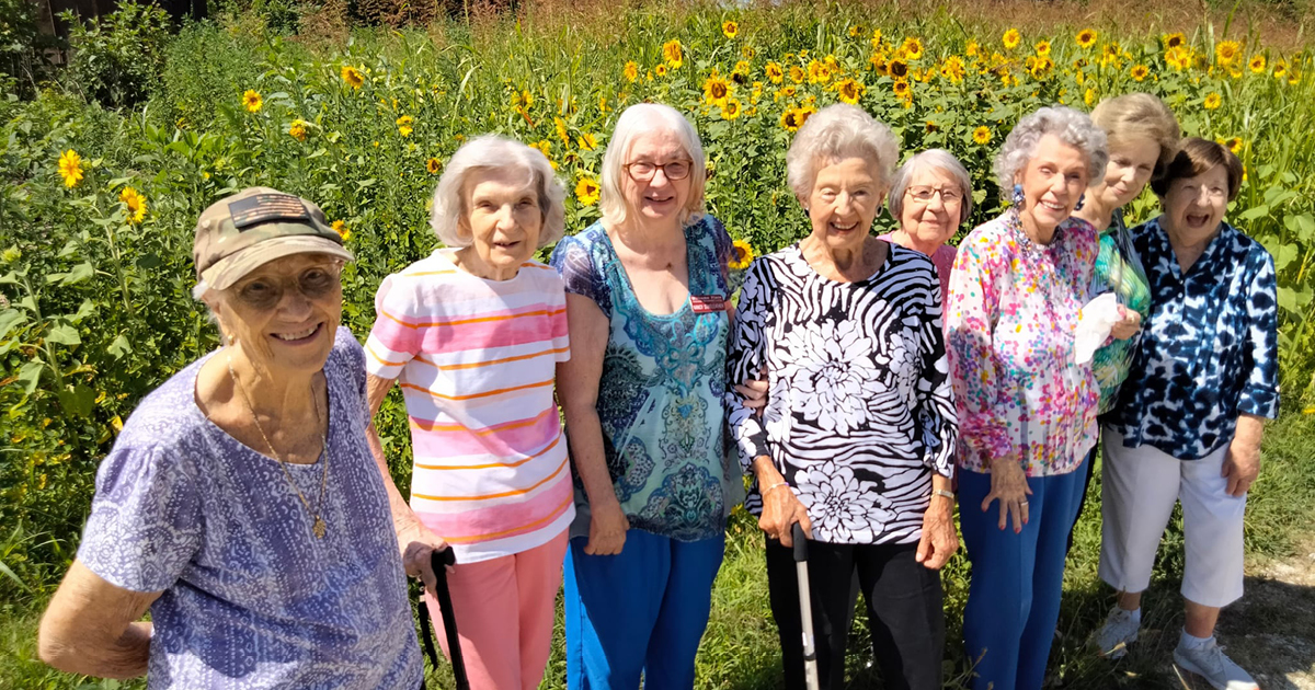 Elderly ladies smiling in a field of flowers
