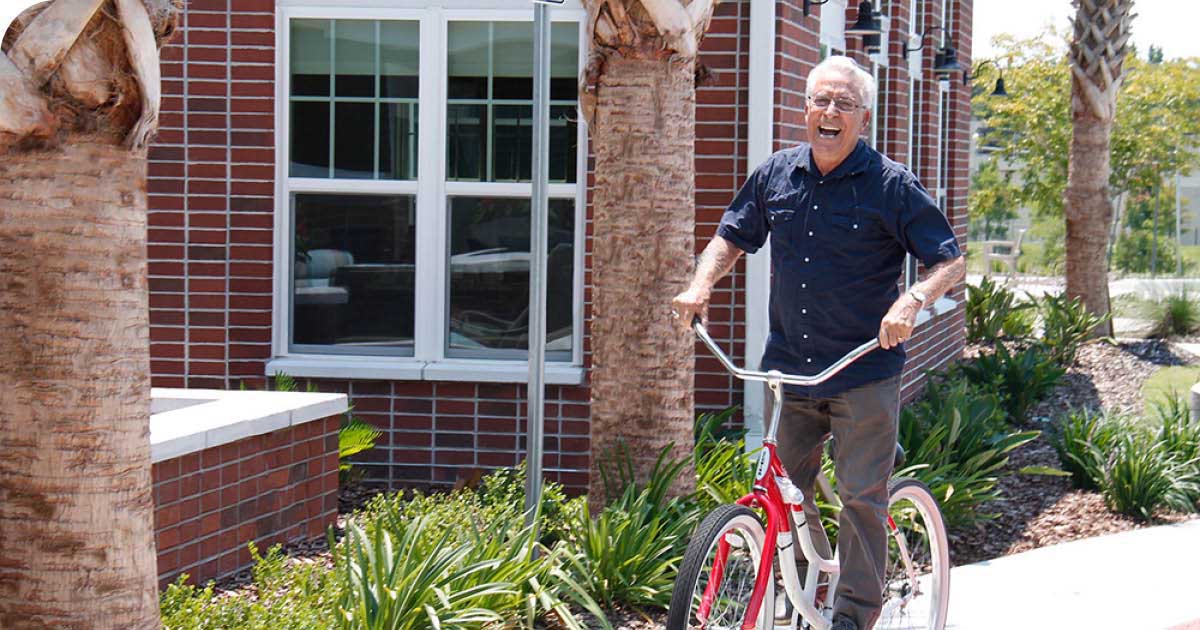 Senior man riding red bicycle outdoors