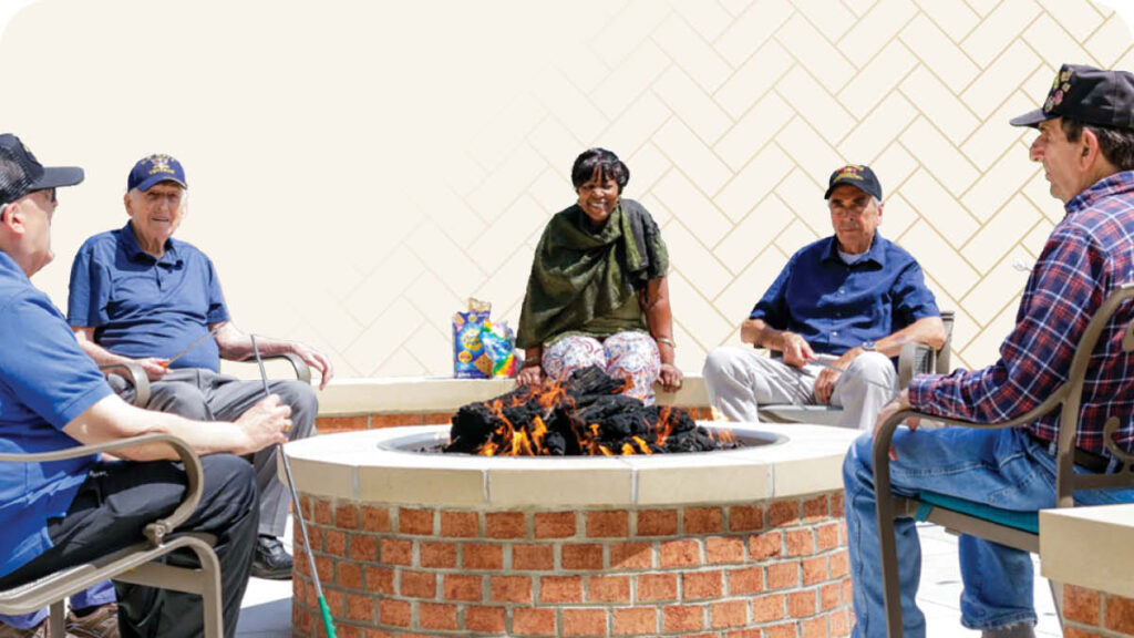 Group of seniors sitting around brick fire pit