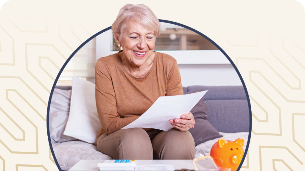 Senior female looking at paperwork with a piggy bank on the table