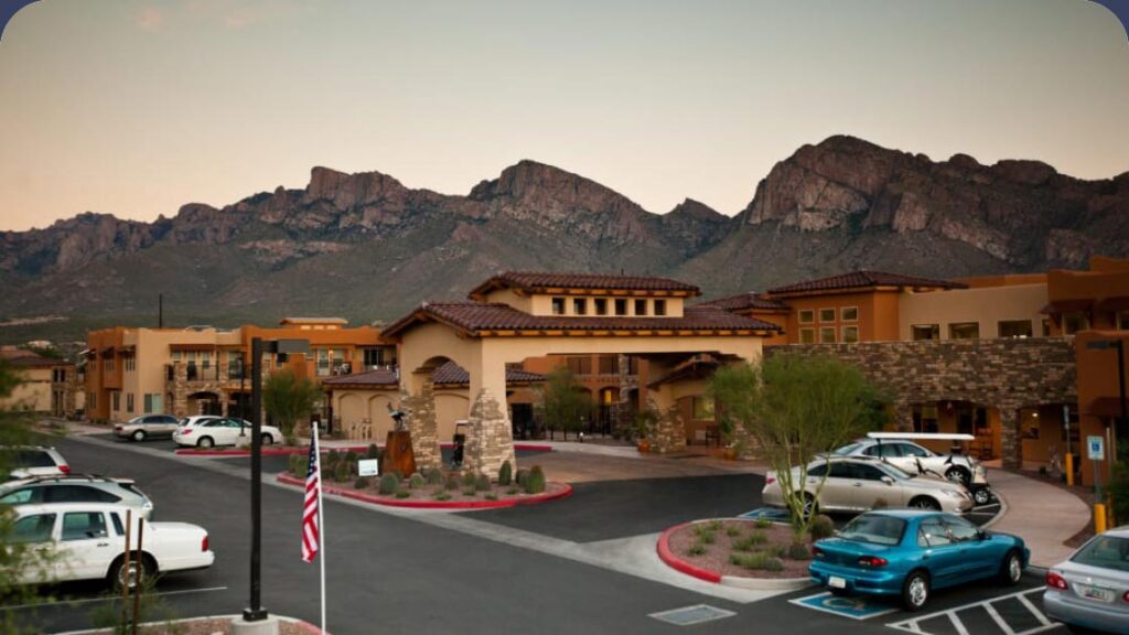 Front exterior of the Desert Springs Gracious Retirement Living building with mountains in background