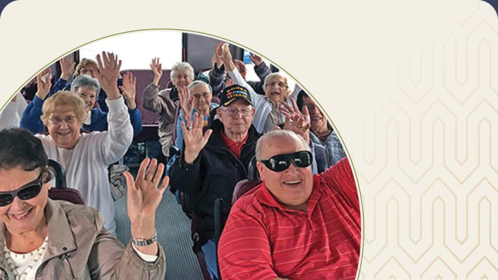 Group of seniors on a bus with their arms raised