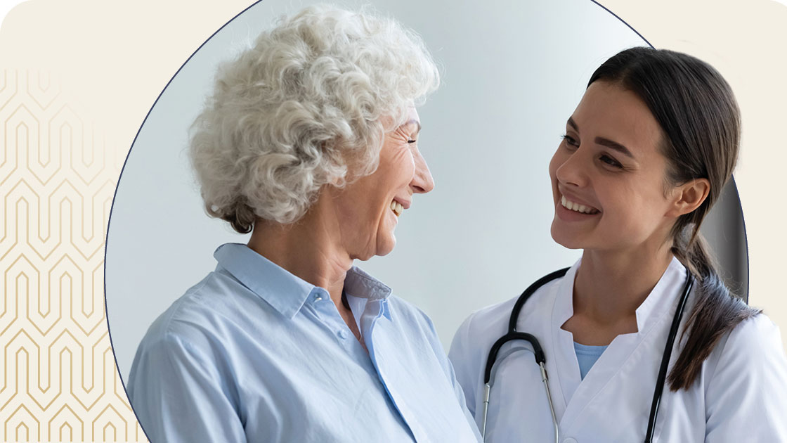 Female nurse and senior woman smiling at each other
