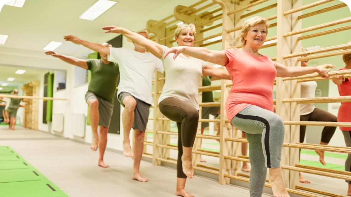 Group of seniors doing balance move while in an exercise class