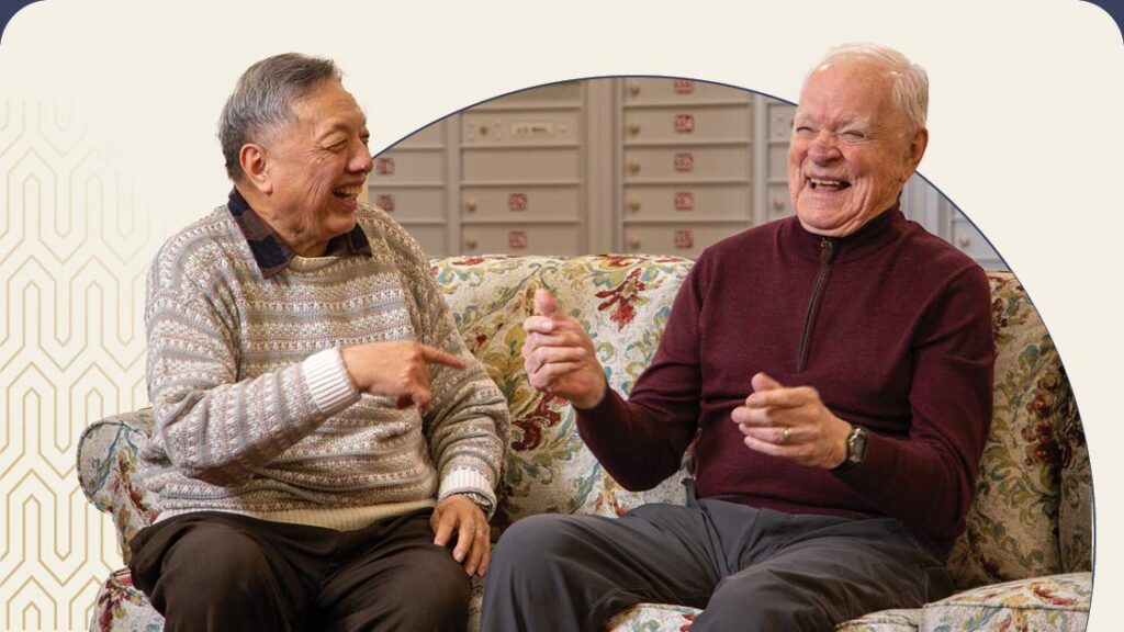 Two senior men sitting on couch and laughing