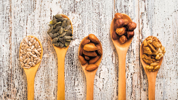 Wooden spoons with different types of nuts on them