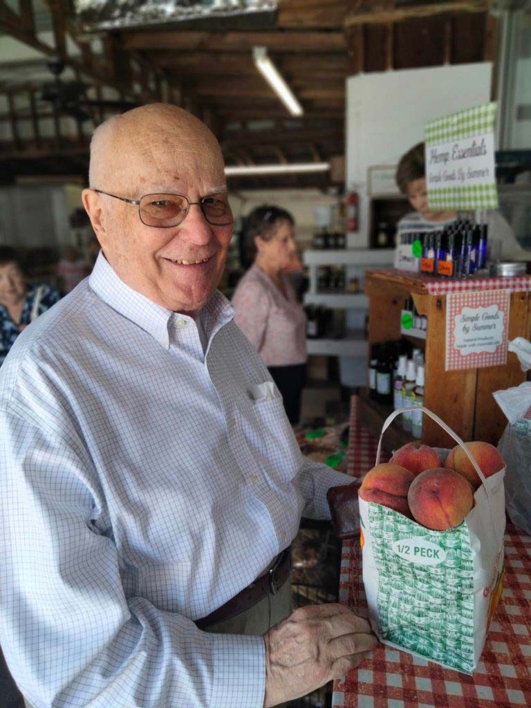 Resident buying peaches at fruit stand