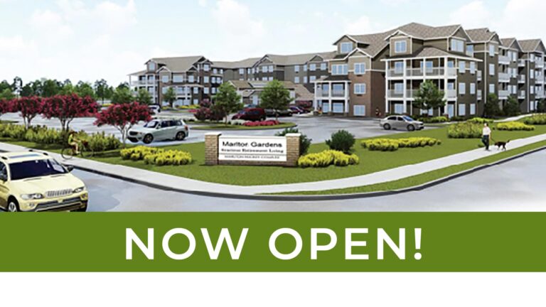 A modern apartment complex with multiple buildings, a parking lot with cars, and landscaping featuring trees and shrubs. A sign reads "Manitou Gardens - Modern Retirement Living." A green banner at the bottom states "NOW OPEN!" in large white letters.