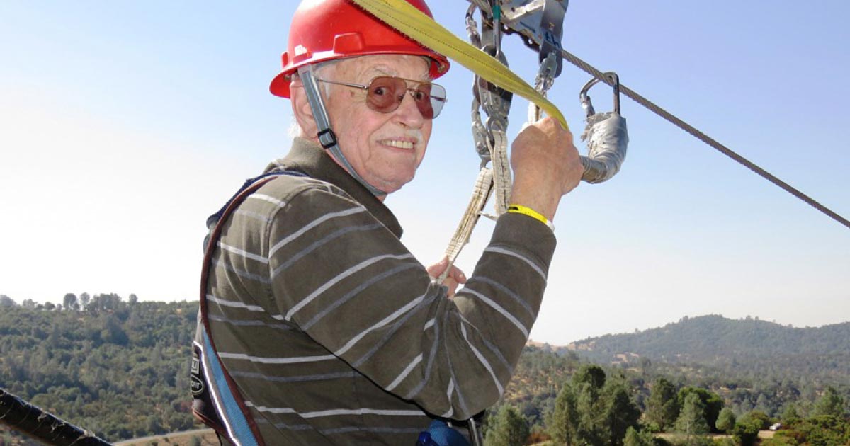 Senior parasailing with red hard hat