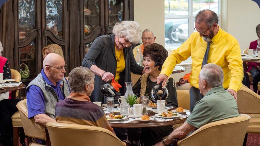 Senior living community staff members serving coffee to senior residents