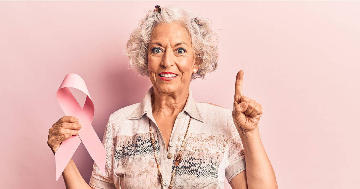 Senior female holding a breast cancer pink ribbon